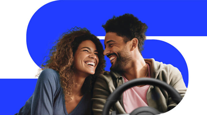 Duas pessoas sorrindo em um carro